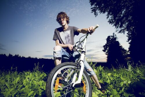 young man on a BMX bike outside looking at camera