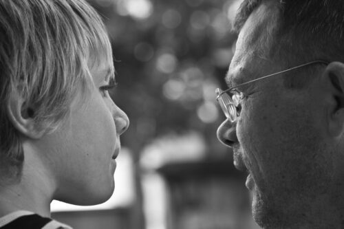 father giving advice to son. Looking from the back looking at eachother in black and white