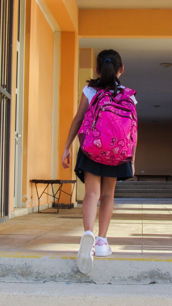 school girl walking with pink bagpack
