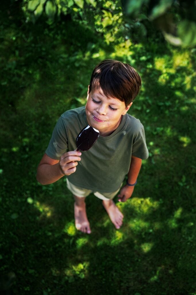 boy eating a snack after playing at the playground