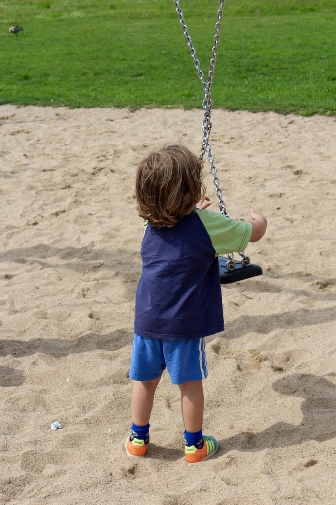 Toddler playing on a playground slide at a neighborhood park